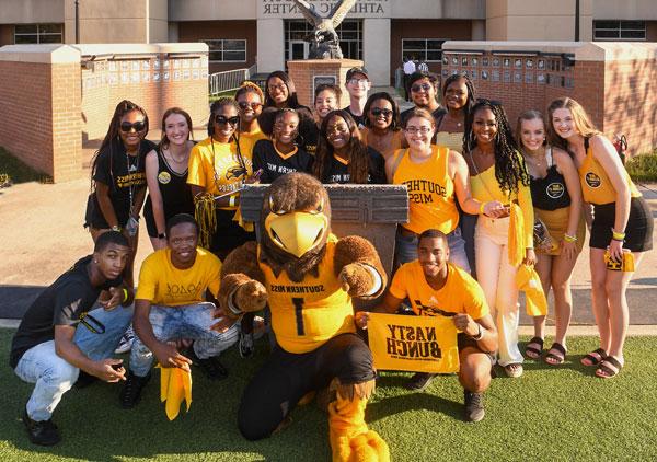 Students dressed in black and gold school colors with mascot Seymour