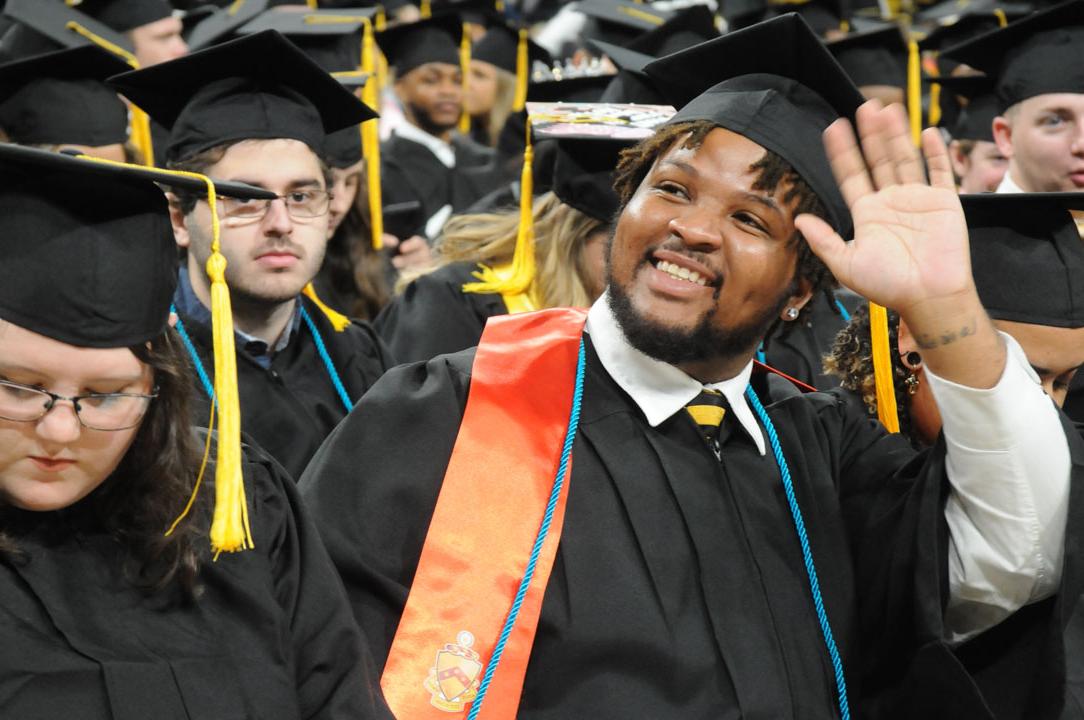 USM student waves to family and friends at commencement. 